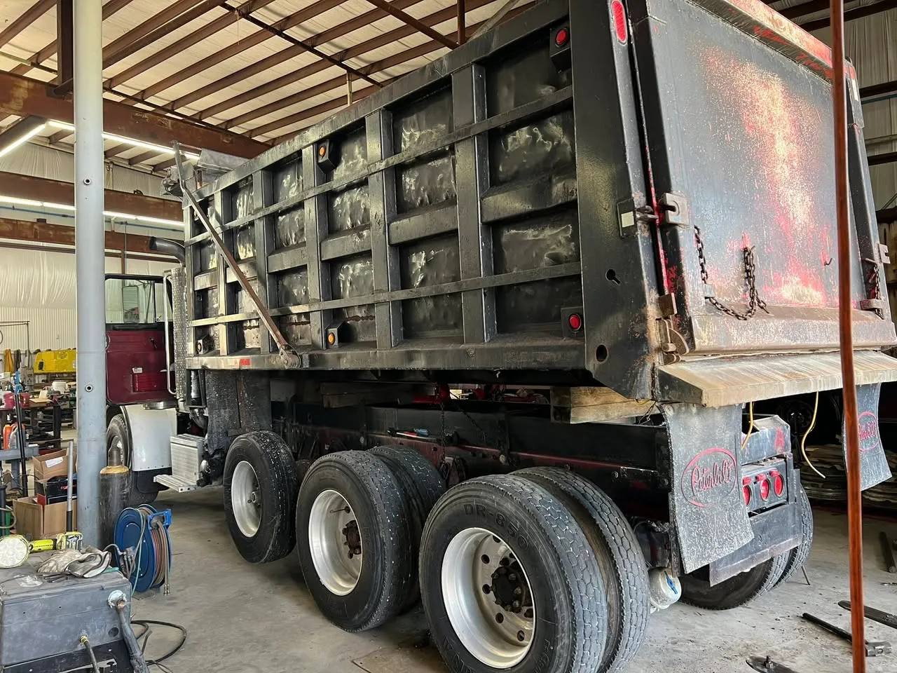 Tri-axle dump truck in the shop for a heavy repair